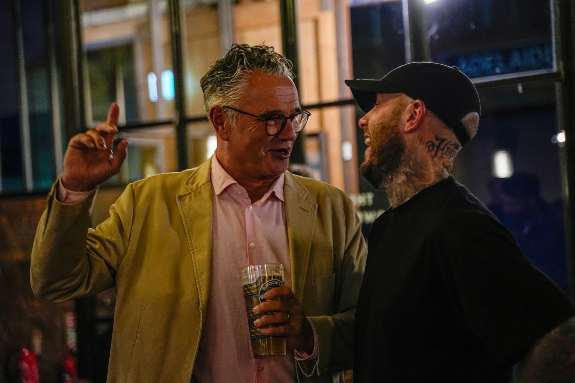 Oly Newton laughing in conversation with a guest at his book launch night in Sheffield